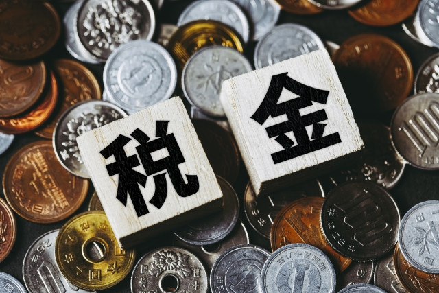 大量の硬貨の上にある税金の文字